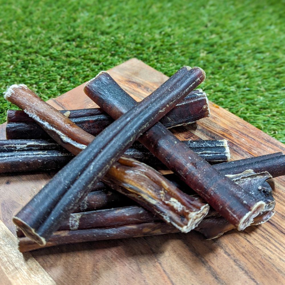 beef bully sticks dog treat on wooden board