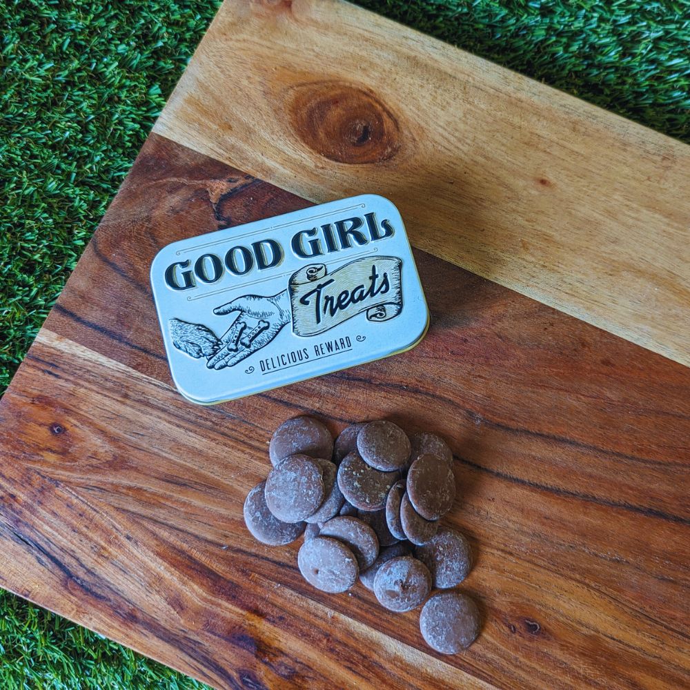 Retro good girl dog treats tin and carob drops displayed on wooden board Bonza Dog Treats