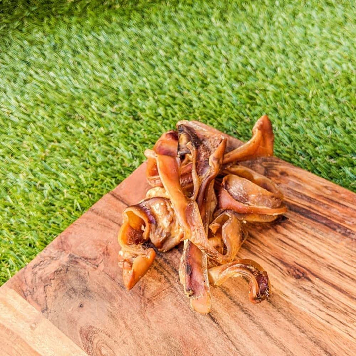 Pile of Australian Pig Ear Strips, a natural pork chew designed for puppies, small dogs, and seniors for gentle dental health | Bonza Dog Treats