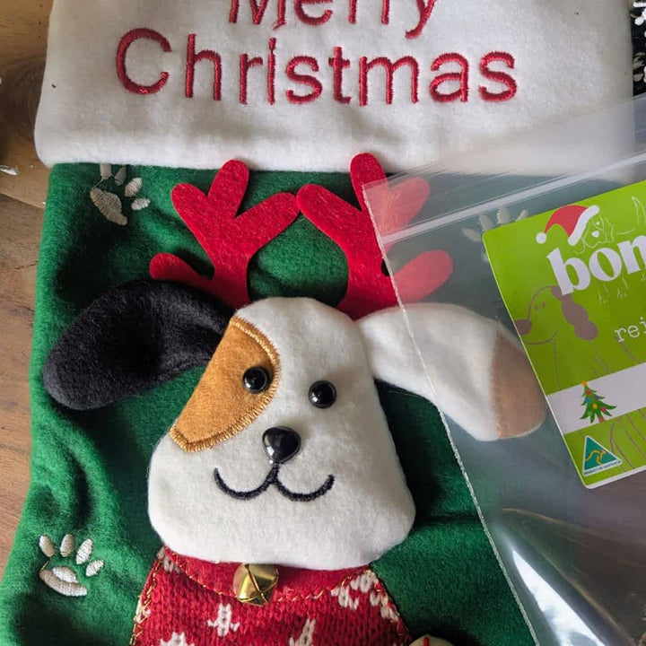Reusable Santa Stocking stuffed with 6 exclusive festive dog treats, including cookies, bonbons, and venison jerky, the perfect Christmas gift for dogs | Bonza Dog Treats
