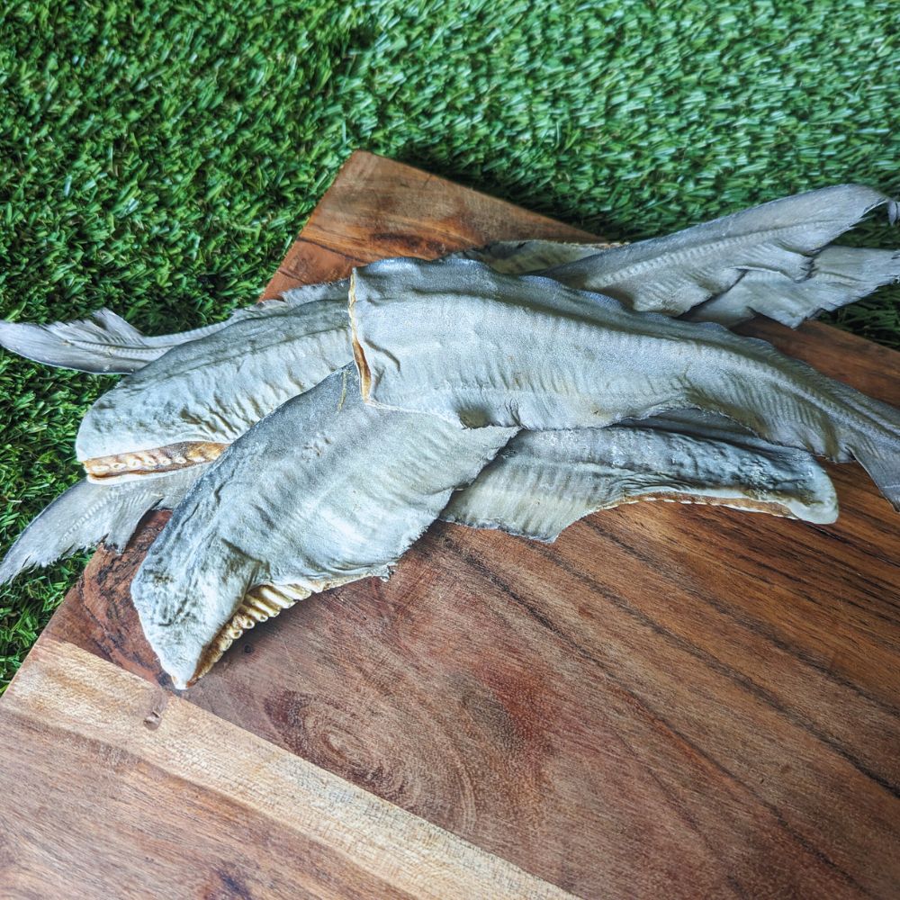 shark tail tips treat for medium sized dogs on wooden board  laying on grass Bonza Dog Treats