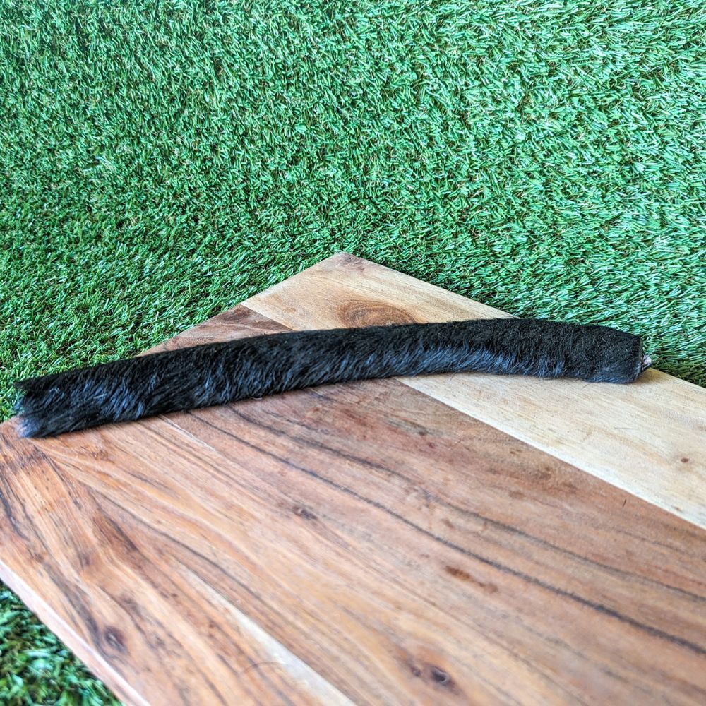 XLarge hairy beef hide scroll on wooden board laying on grass Bonza Dog Treats
